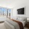 bedroom surrounded by windows with city views